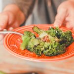 a plate of broccoli on an orange plate be served